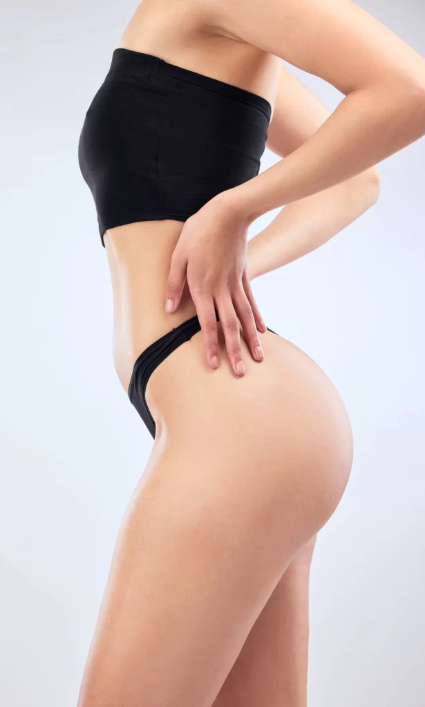 Model in swimsuit bottoms showing toned physique